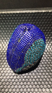 Close-up of geometric blue rhinestones and silver metal frame on a shark evening bag