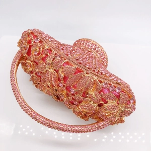 Detailed macro view of pink rhinestones and floral metal hollow pattern on basket clutch