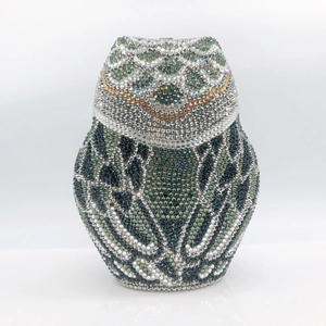 Macro detail of luxury owl clutch bag with hand-set colorful sparkling rhinestones