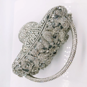 Detailed view of luxury basket clutch with white rhinestones and floral metal carving