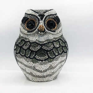 Detail of owl-shaped clutch bag featuring multi-color crystals and black gemstone eyes