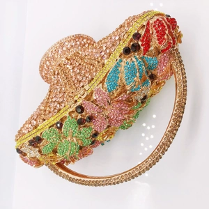 Macro view of crystal basket clutch with colorful floral pattern and rhinestone handle