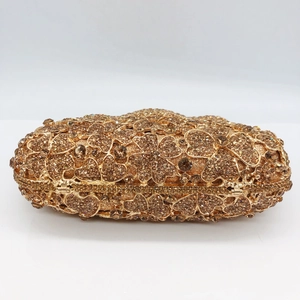 Detailed macro view of gold crystal clutch bag with intricate floral rhinestone patterns