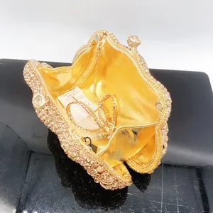Detailed view of champagne gold crystal clutch bag with metal chain and luxury rhinestones