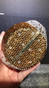 Macro shot of owl clutch bag featuring golden and silver rhinestones on a hard shell