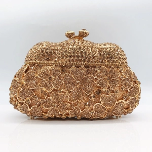 Close-up of golden clover crystal clutch bag with champagne rhinestones and metal clasp