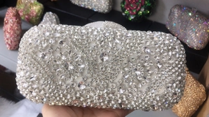 Macro detail of a silver rhinestone evening clutch bag with intricate floral crystal patterns