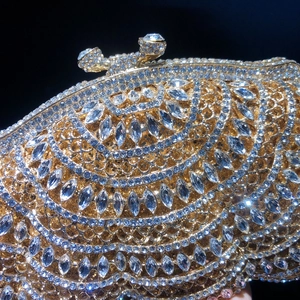 Pochette de soirée dorée de luxe avec strass étincelants sur un fond noir élégant