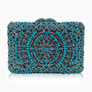 Detail of blue rhinestone evening clutch showing intricate hollow metal mandala pattern