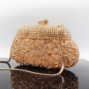 Detailed macro of champagne gold crystal evening clutch bag with 3D flower and chain strap