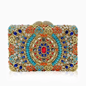 Macro detail of multicolored crystals and heart clasp on golden evening clutch bag