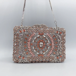 Detailed view of silver rhinestone evening clutch bag with heart clasp and chain strap