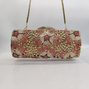 Detail of evening clutch bag with pink cherry blossom crystals and gold chain strap