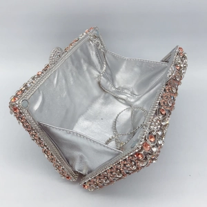 Detailed interior of silver rhinestone clutch bag with pearl lining and metal chain