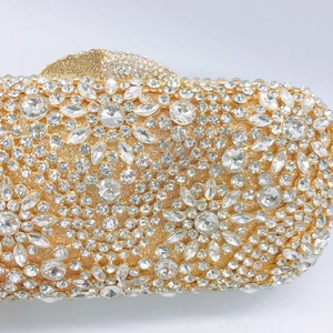 Close-up of golden evening clutch featuring intricate floral rhinestone and crystal patterns