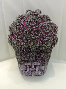 Détail d'une pochette de soirée rose en cristal violet avec base en métal tressé
