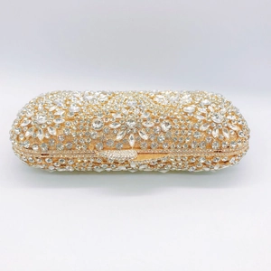 Detailed close-up of sparkling silver rhinestones on golden evening clutch bag frame