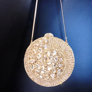 Detailed view of luxury gold round clutch bag encrusted with crystal rhinestones