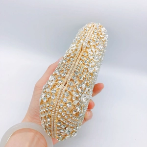 Macro shot of shimmering rhinestones on a gold-tone hard shell clutch evening bag