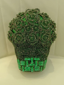 Gros plan détaillé d'une pochette de soirée rose en cristal vert émeraude aux détails ornés