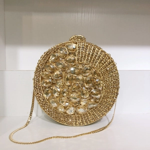 Close-up of luxury gold evening clutch featuring oversized crystals and teardrop gemstones