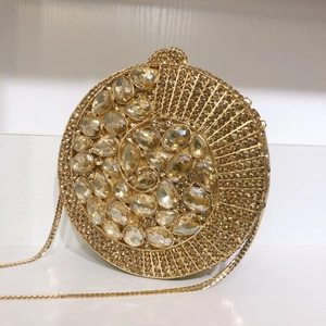 Detailed close-up of golden evening clutch with crystal inlay and large acrylic gems