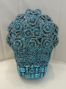 Détail d'une pochette de soirée de luxe bleue avec cristaux et design de panier de roses