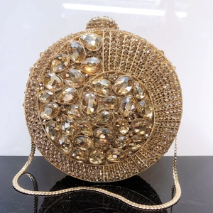 Macro detail of the golden frame encrusted with varied crystals on a round evening clutch