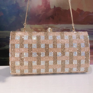 Macro view of crystal rhinestones with woven checkered pattern on champagne evening clutch