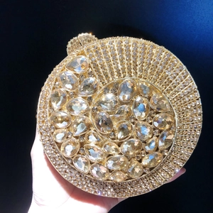 Macro view of shell-shaped gold evening clutch bag with sparkling crystals and diamonds