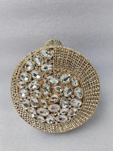 Macro shot of gold spiral evening clutch with dazzling white rhinestones and crystals
