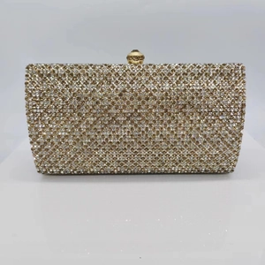 Detailed view of champagne crystal studded rectangular evening clutch with golden sphere clasp