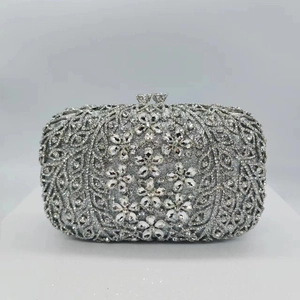 Macro view of crystal floral embellishments on silver sparkling hard shell evening clutch
