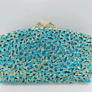 Exquisite hollow metal clutch bag with blue crystals and gold clasp for evening banquet