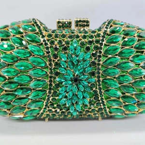 Détail d'une pochette de soirée verte avec motif floral en strass et fermoir doré chic