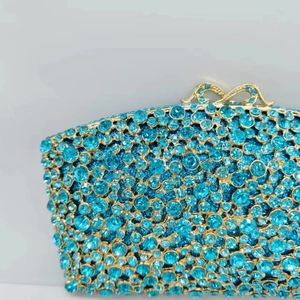 Macro shot of turquoise crystals and gold metal clasp on a luxury evening clutch bag