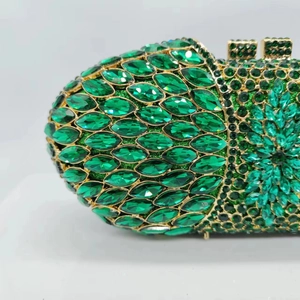 Détails des cristaux vert émeraude sur une pochette de soirée de luxe dorée