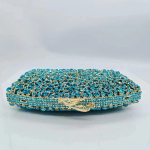Detailed close-up of luxury evening clutch with blue gradient crystals and gold metal frame