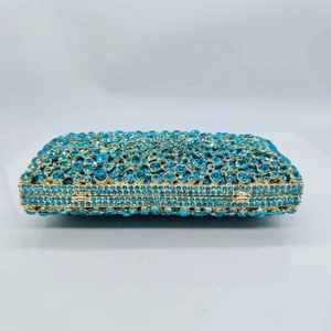 Macro detail of luxury rectangular clutch with deep blue rhinestones and gold metal frame