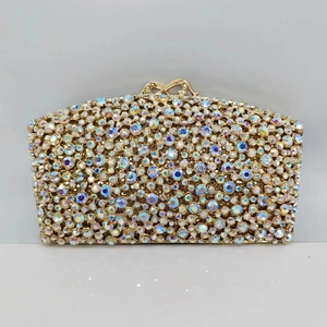 Close-up of luxury evening clutch with colorful rhinestones and gold bow clasp