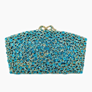Detailed close-up of blue crystal rhinestones and golden bow clasp on evening clutch bag