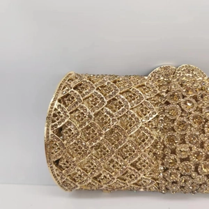 Vue détaillée d'une pochette de soirée dorée avec écailles de cristal et motifs floraux