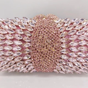 Close-up of pink crystal embellishments and hollowed metal frame on luxury handbag