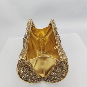 Détail d'une pochette de soirée luxe avec texture en cristal champagne et intérieur doré