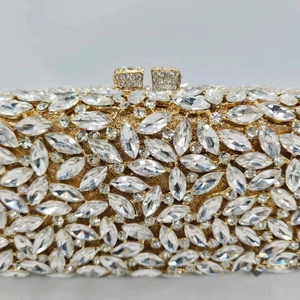 Détail d'une pochette dorée en métal avec strass marquise étincelants et fermoir en cristal