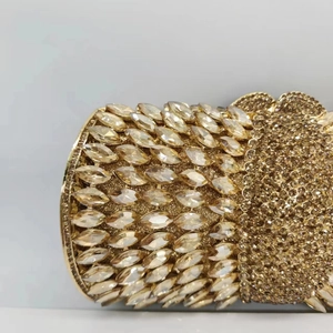 Detail of hand-set marquise crystals on luxury gold metal evening clutch bag