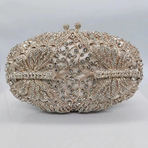 Detail of silver crystal butterfly clutch bag with intricate gold镂空work and rhinestone clasp