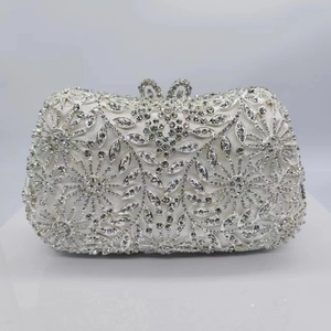 Détail d'une pochette de luxe en strass argentés avec motifs floraux et fermoir cœur