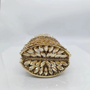 Detail of gold metal frame and sparkling crystal flower pattern on an oval evening bag