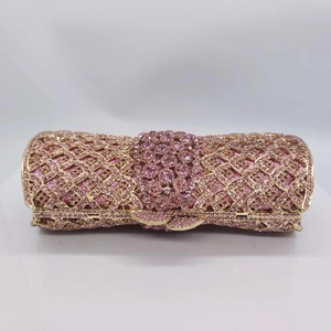 Détail macro de la pochette de soirée en métal doré avec strass roses incrustés